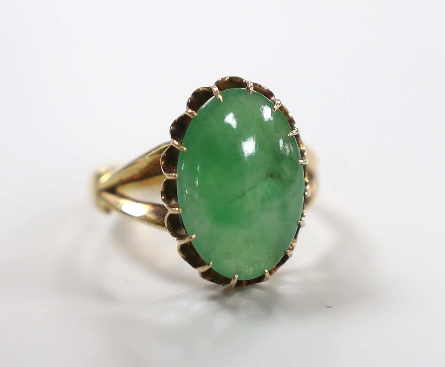 A Chinese yellow metal and cabochon jade set oval ring, size Q/R, gross weight 5 grams.